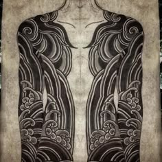 the back of a man's body covered in black and white ink with intricate designs