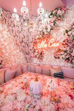 a room with pink flowers on the walls and chandelier hanging from the ceiling