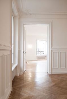 an empty room with white walls and wood flooring is pictured in this image from the doorway