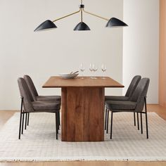 a dining room table with four chairs and a bowl on the center piece in front of it