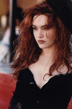 a woman with red hair is posing for the camera