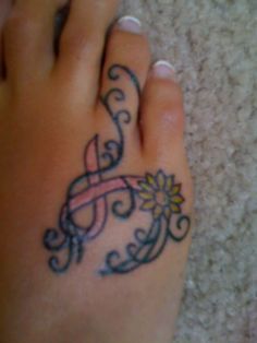 a foot with a pink ribbon on it and a flower in the middle of it