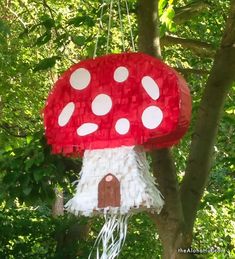 a red mushroom house hanging from a tree