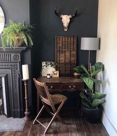 a room with a desk, chair and potted plants