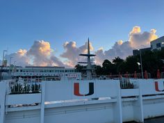 a large white building with red and green letters on it's sides, in front of a cloudy sky