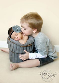 two young children cuddle together in a basket