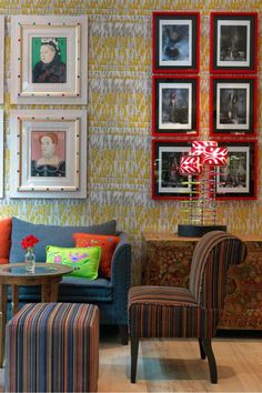 a living room filled with colorful furniture and pictures on the wall above it's coffee table