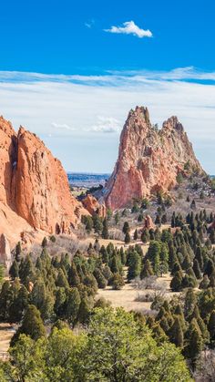 the mountains are covered with trees and rocks in the distance is a valley that has many tall, red rock formations