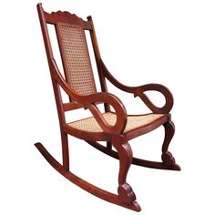 a wooden rocking chair with wicker seat and arm rests on an isolated white background