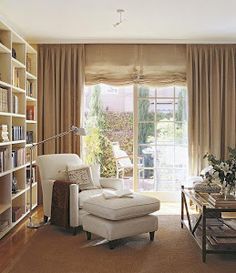 a living room filled with furniture and a large window covered in beige drapes