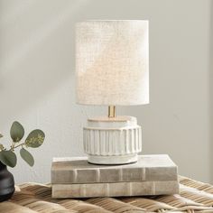 a white lamp sitting on top of a wooden table