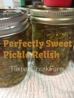 three jars filled with pickles sitting on top of a table