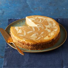 a cheesecake sitting on top of a blue plate with a knife next to it