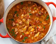 a red pot filled with soup on top of a white table