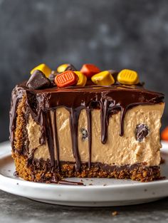 a piece of cake on a white plate with chocolate drizzle and candy candies