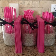 three mason jars filled with pink and silver glittery utensils, tied in black ribbon