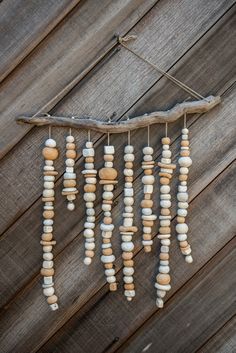 a wind chime made out of rocks and driftwood hanging on a wooden fence