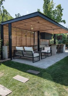 a covered patio with chairs and tables in the grass