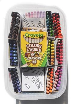 a container filled with lots of crayons on top of a table