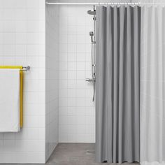 a bathroom with a shower curtain and white tile walls