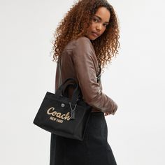 Carry as much (or as little) as you like with our lightweight Cargo tote. Detailed with our cursive Coach script embroidery and iconic turnlock closure this compact 26 has an open interior with room for an iPad two outside pockets for easy organization and a removable webbing strap for shoulder or crossbody wear. Crafted to last this versatile carryall is made with cotton sourced from farms that use regenerative agricultural practices* and inspired by our commitment to reducing our impact on the Luxury Calvin Klein Shoulder Bag, Coach Bags Handbags 2022, Coach Handbags Coach, Luxury Calvin Klein Shoulder Bag For Everyday, Luxury Everyday Calvin Klein Shoulder Bag, Coach Bags Handbags Coach, Coach Bag Blck, Coach Hamdbags, Everyday Calvin Klein Shoulder Bag