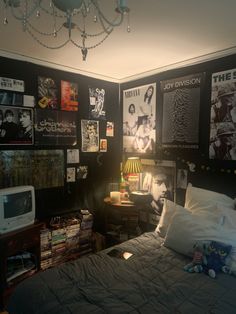 a bed room with a neatly made bed and lots of posters on the wall