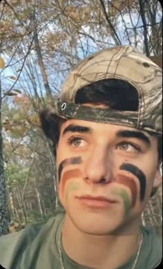 a young man with his face painted in camouflage