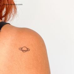 a woman with a small saturn tattoo on her back