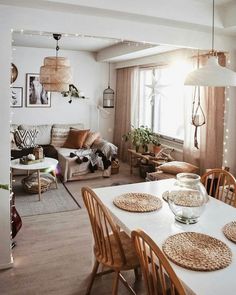 a living room filled with furniture next to a dining room table and chairs in front of a window