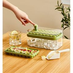 a person is picking up an item from a container on a table with ice cubes