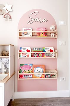 a child's room with pink walls and shelves