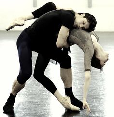 two ballerinas in black and white are performing on the dancefloored floor