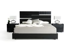 a black and white bed with two nightstands next to it on a white floor