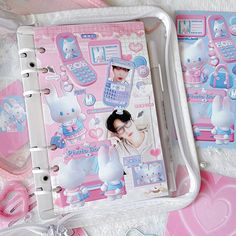 a pink and white binder with hello kitty stickers on it next to other items