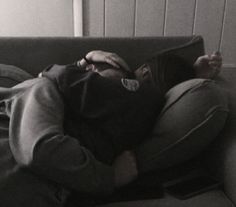 black and white photograph of a person laying on a couch with their head resting on a pillow