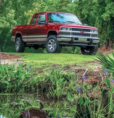 a red pick up truck parked in the grass