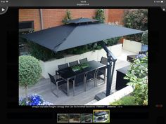 an image of a patio with table and chairs under an umbrella in the middle of it