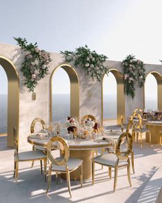 an outdoor dining area with tables, chairs and archways on the wall overlooking the ocean