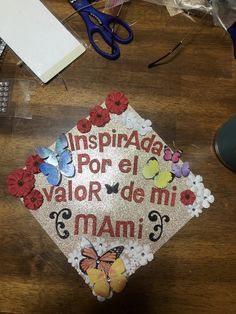 a cap that has been decorated with flowers and butterflies on the front is sitting on a table