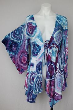 a white mannequin wearing a purple and blue shirt with an abstract print on it