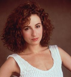 a close up of a person wearing a white shirt and posing for a photo with her hands on her hips