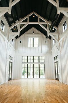 the inside of a large white building with wooden floors and black trimmings on the walls