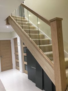 a staircase with glass railing and wooden handrail