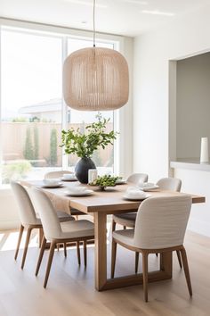 a dining room table with chairs and a vase on it