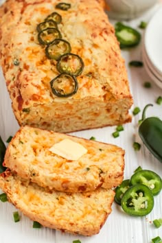 two slices of bread with cheese and jalapenos next to them on a white surface