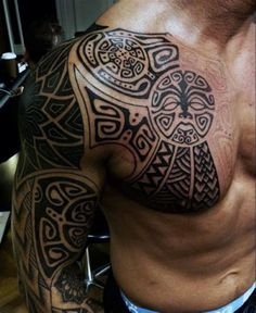 a man's chest with an intricate tattoo design on his left arm and shoulder