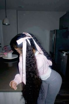 a woman with long hair standing on top of a counter