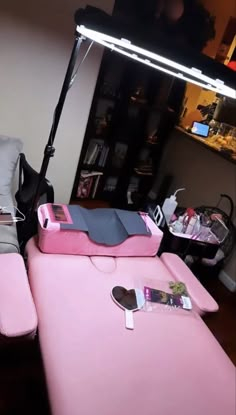 a pink bed sitting in the middle of a living room next to a chair and lamp