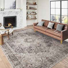 a living room filled with furniture and a fire place next to a large rug on top of a hard wood floor