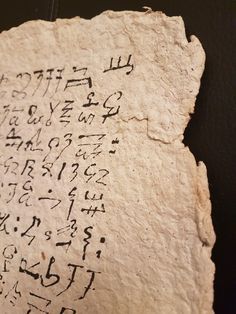 an ancient writing on a piece of paper with cursive writing written in it